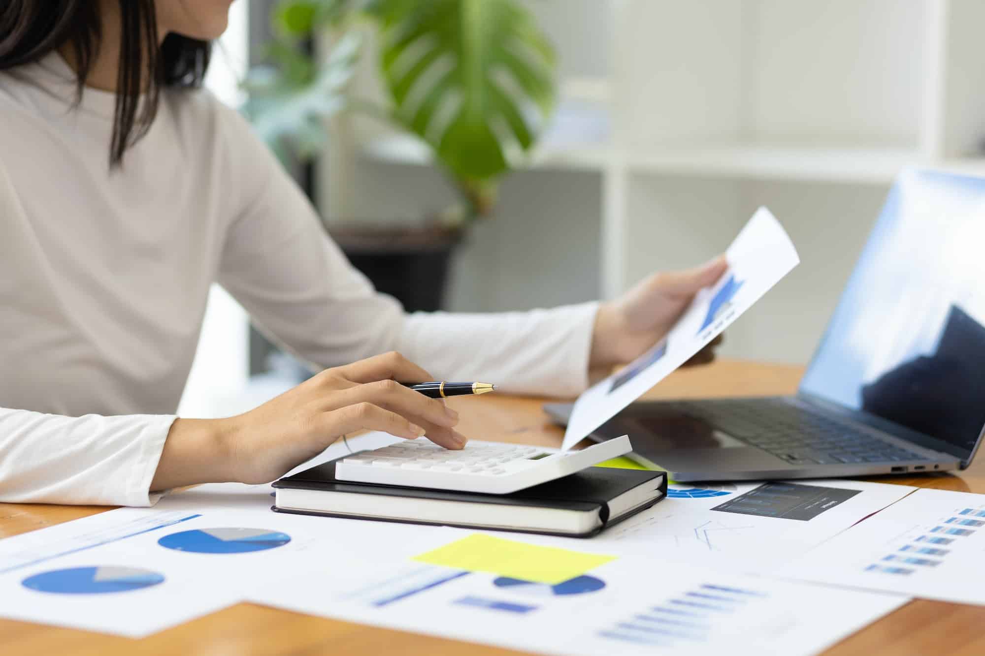 Female accountant in office calculating and analyzing financial accounts.